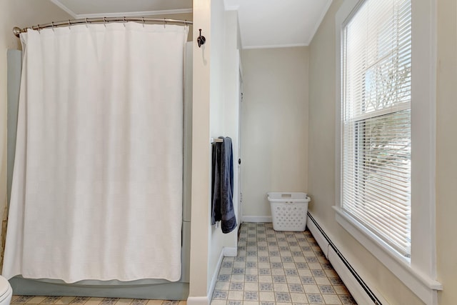 bathroom with ornamental molding, plenty of natural light, and a baseboard heating unit