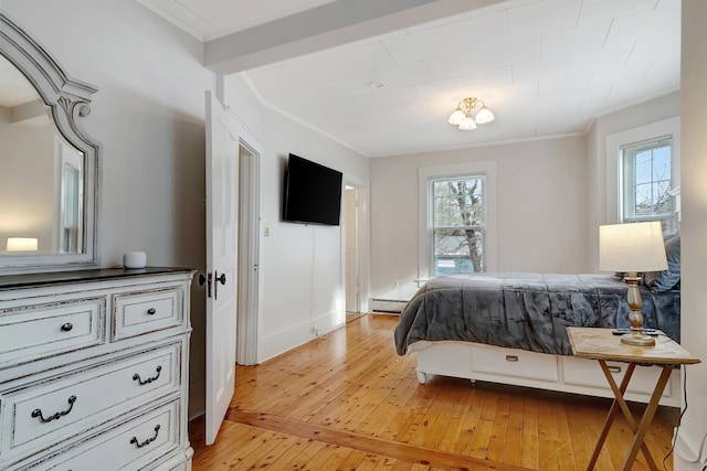 bedroom with a baseboard radiator, light hardwood / wood-style flooring, and crown molding