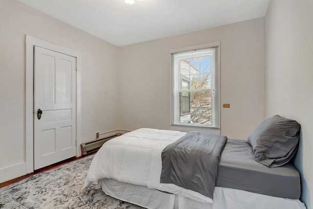 bedroom with wood-type flooring and a baseboard radiator