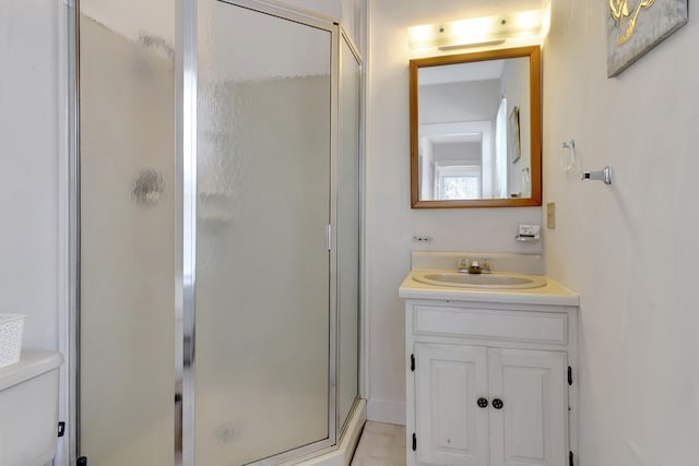 bathroom featuring tile patterned floors, vanity, toilet, and an enclosed shower