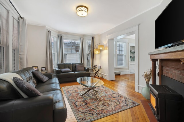 living room with a baseboard radiator, light hardwood / wood-style flooring, and crown molding