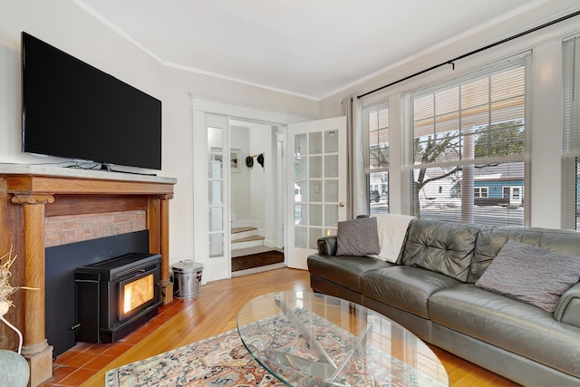 living room featuring light hardwood / wood-style floors, a wood stove, and crown molding