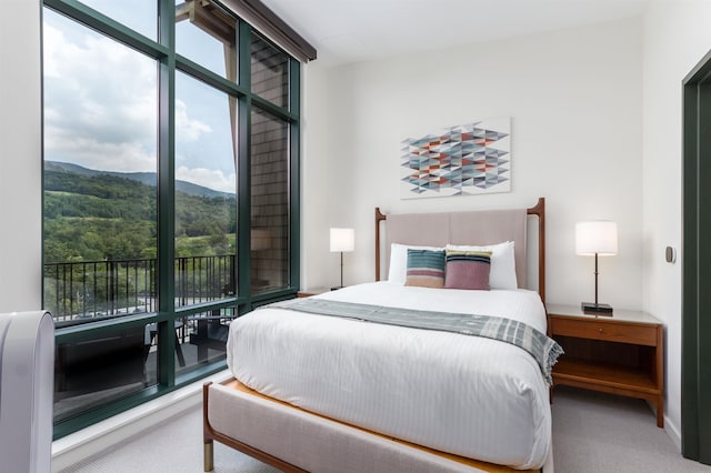 bedroom featuring carpet flooring, multiple windows, and a mountain view