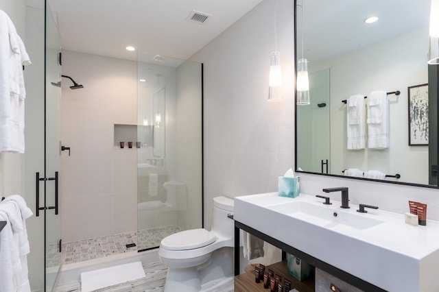 bathroom with hardwood / wood-style flooring, toilet, a shower with shower door, and sink