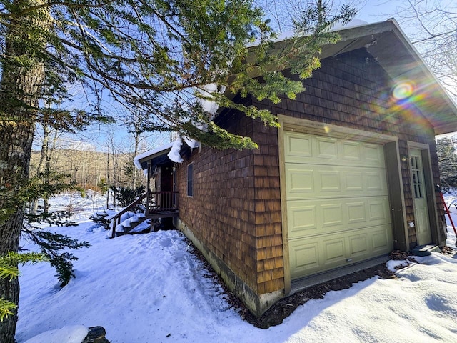 view of snowy exterior featuring a garage