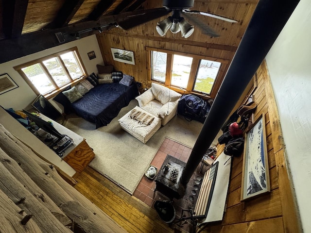 living room featuring beam ceiling, plenty of natural light, ceiling fan, and wooden ceiling