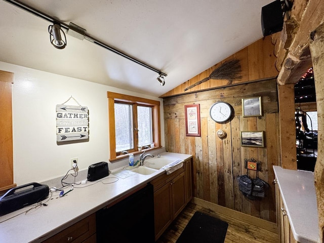 bathroom featuring sink, hardwood / wood-style flooring, vaulted ceiling, and wood walls