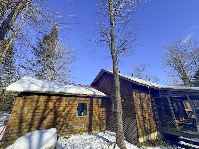 view of snowy exterior featuring a sunroom