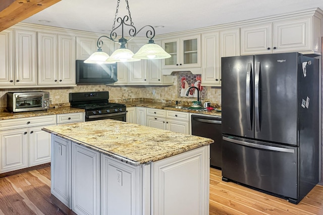 kitchen featuring white cabinetry, hanging light fixtures, and black appliances