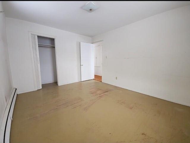 unfurnished bedroom with a closet and a baseboard heating unit