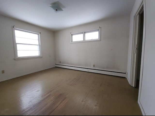 spare room with light wood-type flooring and a baseboard radiator