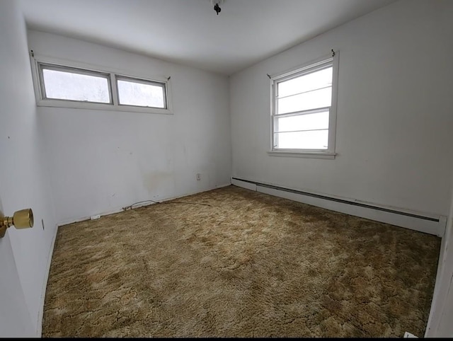 carpeted spare room featuring baseboard heating and a healthy amount of sunlight