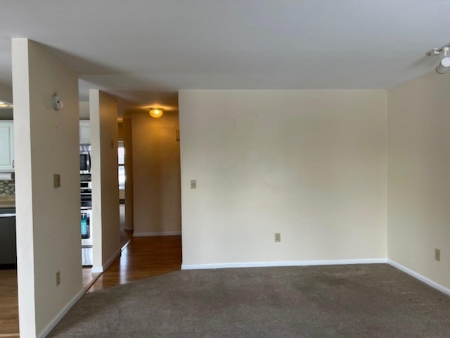 unfurnished room featuring dark carpet