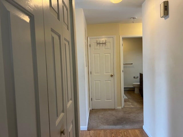 corridor with a baseboard radiator and light wood-type flooring