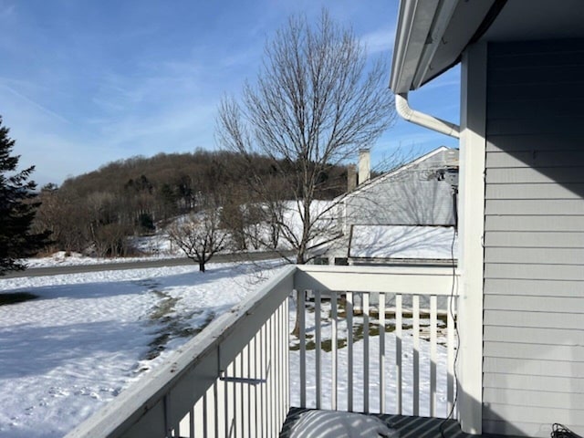 view of snow covered back of property