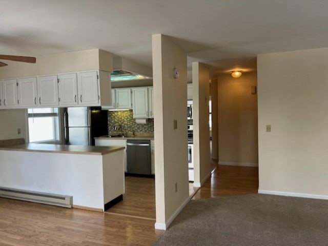 kitchen featuring white cabinets, appliances with stainless steel finishes, light hardwood / wood-style flooring, and baseboard heating