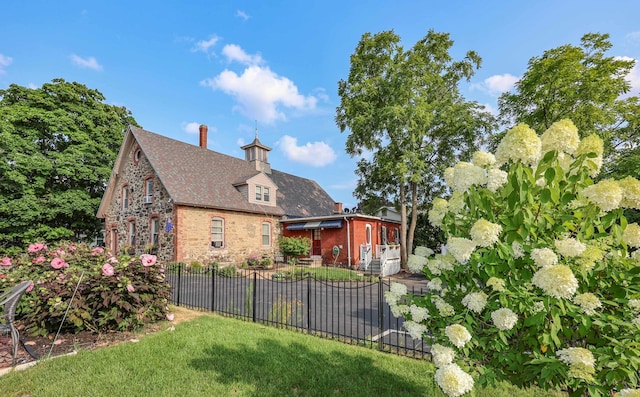 rear view of property with a lawn