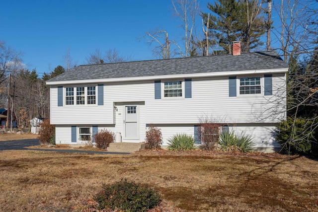 raised ranch featuring a front lawn