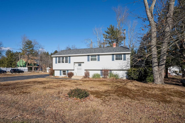 raised ranch featuring a front lawn