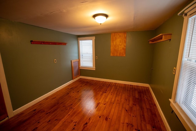 spare room with hardwood / wood-style flooring and a healthy amount of sunlight