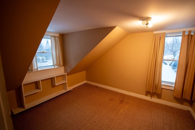 bonus room with carpet flooring and vaulted ceiling