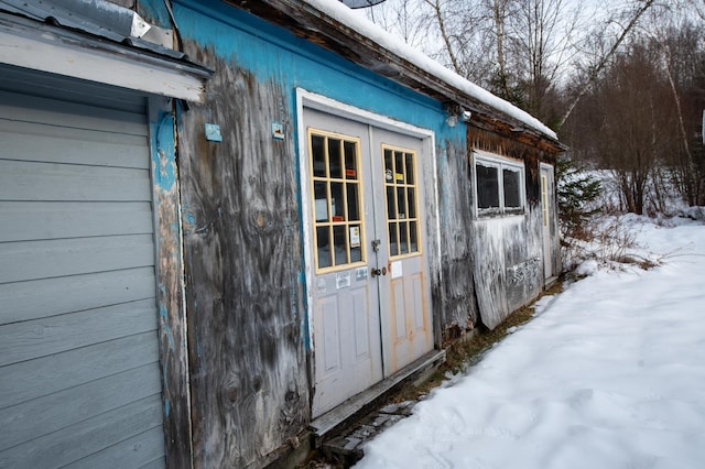 snow covered structure featuring french doors