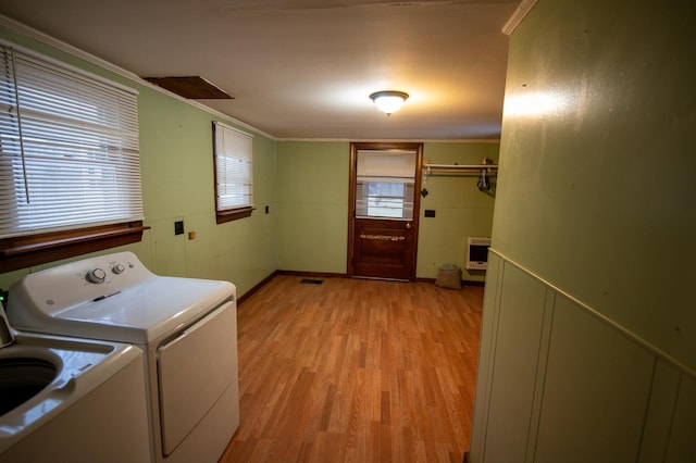 washroom featuring washer and clothes dryer, light hardwood / wood-style floors, crown molding, and heating unit