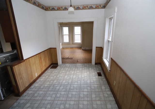 unfurnished dining area featuring wooden walls