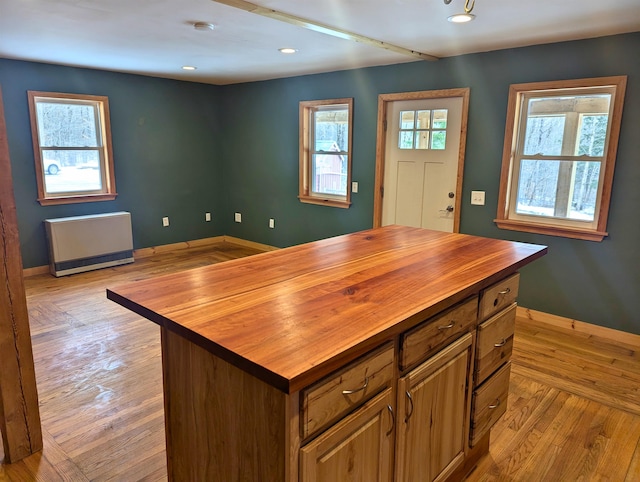 kitchen with wood counters, a center island, and light hardwood / wood-style flooring