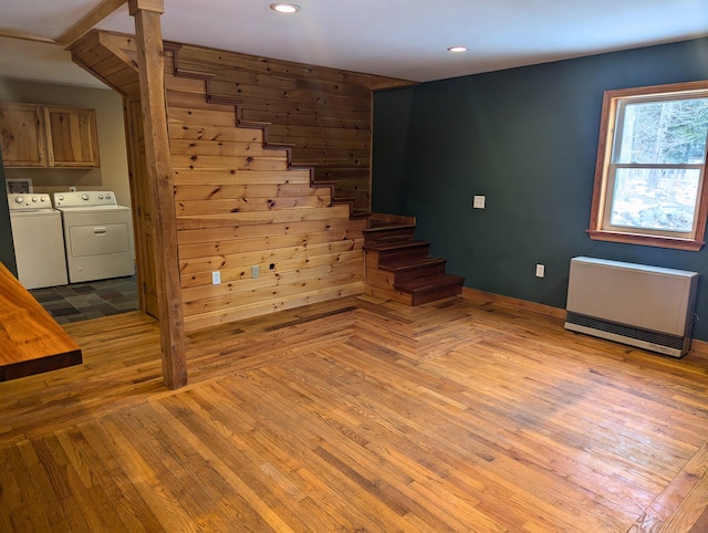 staircase featuring hardwood / wood-style floors, radiator heating unit, and separate washer and dryer