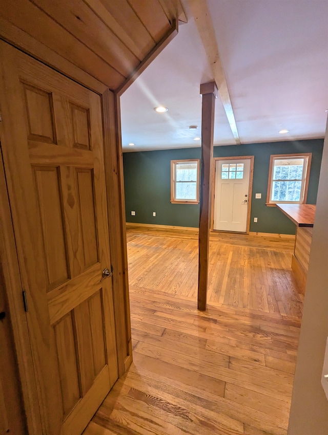 interior space featuring beamed ceiling and light hardwood / wood-style floors