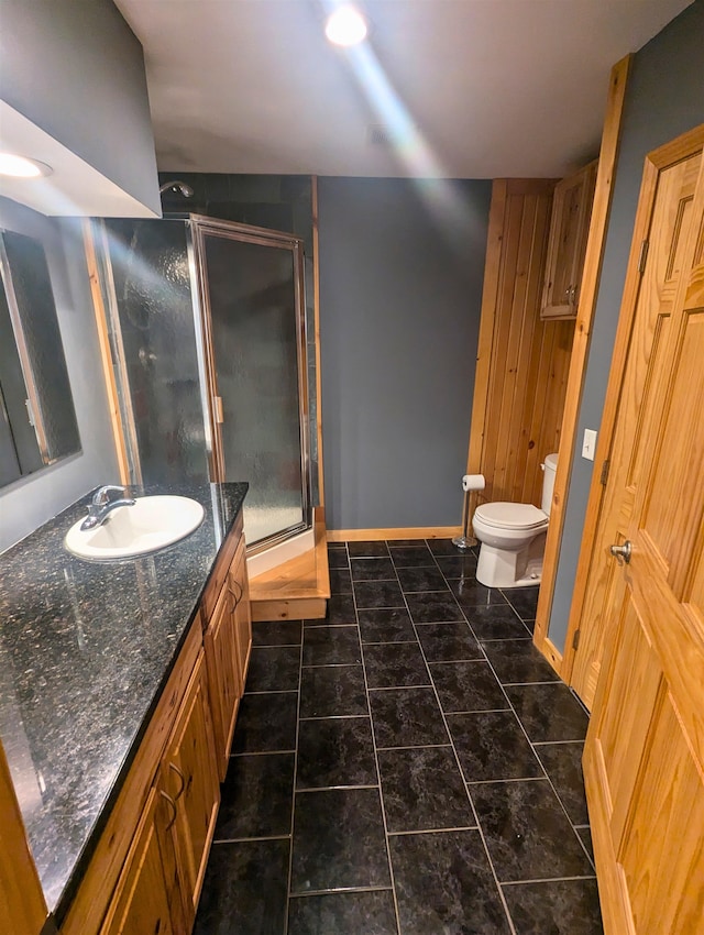 bathroom featuring tile patterned floors, vanity, toilet, and walk in shower