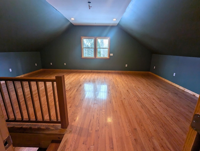 additional living space with vaulted ceiling and hardwood / wood-style flooring