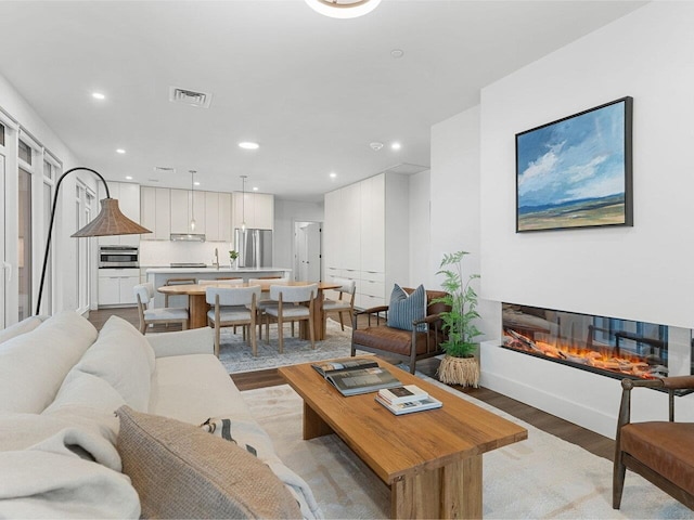 125 Cambrian Way Unit 609, Burlington, VT 05401 - living area with light wood-type flooring, recessed lighting, and a glass covered fireplace