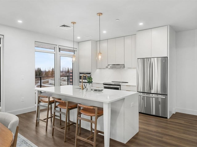 125 Cambrian Way Unit 609, Burlington, VT 05401 - kitchen with appliances with stainless steel finishes, dark wood-type flooring, a center island with sink, light countertops, and baseboards