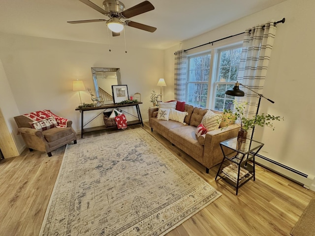 living room with wood-type flooring, baseboard heating, and ceiling fan