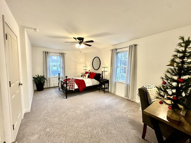 carpeted bedroom featuring ceiling fan and multiple windows