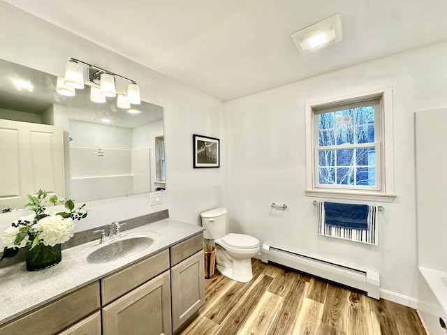 full bathroom with toilet, hardwood / wood-style flooring, shower with separate bathtub, a baseboard heating unit, and vanity