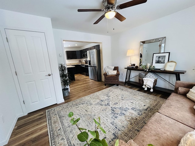 interior space featuring baseboards, a ceiling fan, and dark wood-style flooring