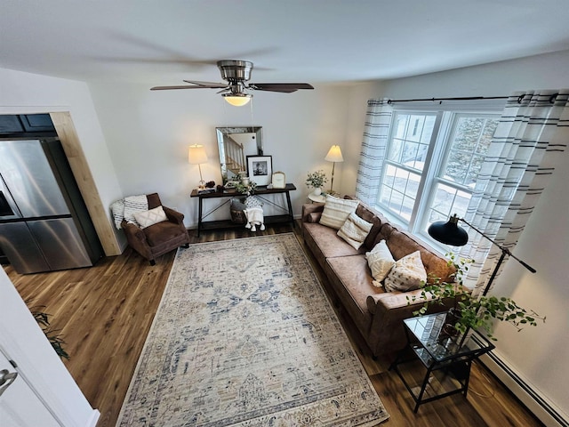living area with a ceiling fan, wood finished floors, baseboards, and a baseboard radiator