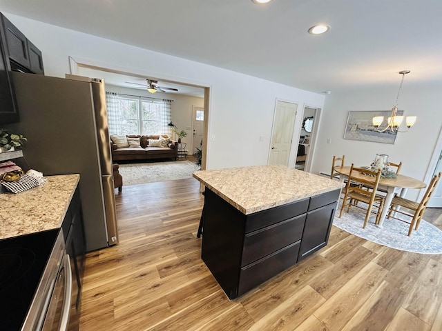 kitchen featuring light wood-style flooring, a kitchen island, and dark cabinetry