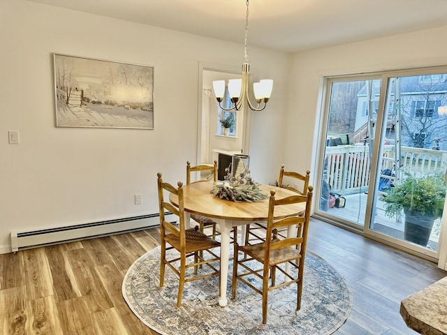 dining room with baseboard heating, a notable chandelier, and hardwood / wood-style floors