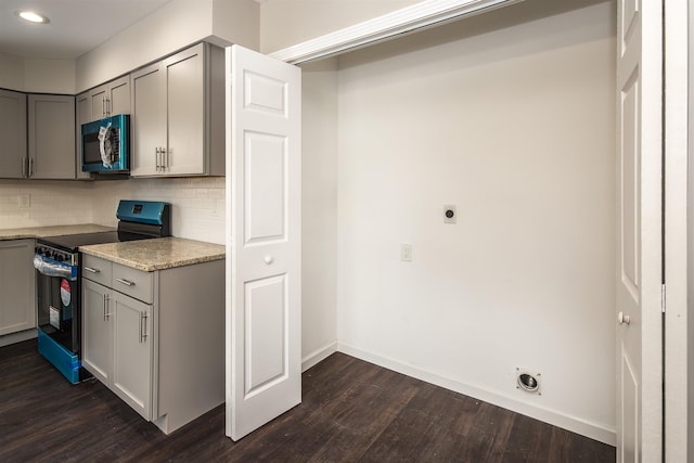 kitchen featuring decorative backsplash, light stone counters, gray cabinetry, dark wood-type flooring, and electric range