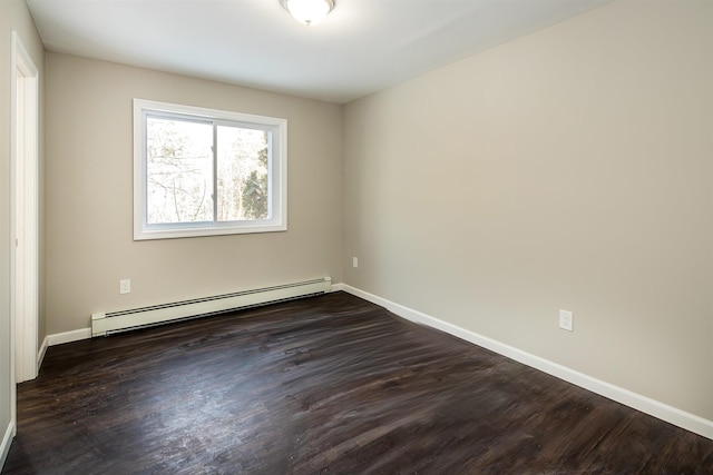 spare room with dark hardwood / wood-style flooring and a baseboard heating unit