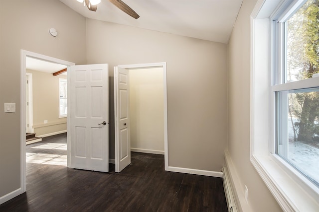 interior space featuring lofted ceiling, dark wood-type flooring, and multiple windows