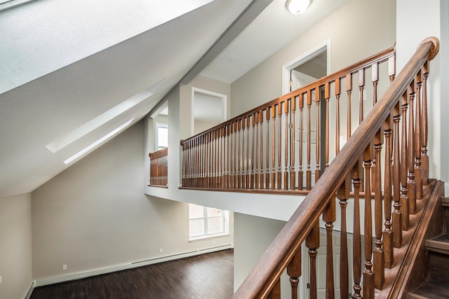 stairway with wood-type flooring, lofted ceiling, and baseboard heating