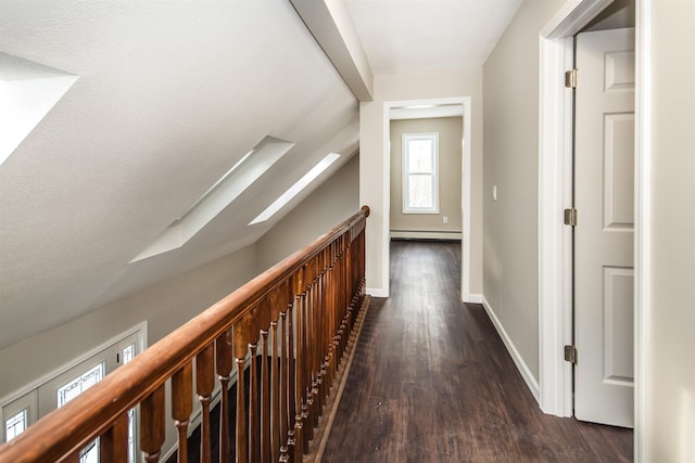 hall with dark wood-type flooring, lofted ceiling, and a baseboard heating unit