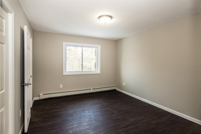 spare room with a textured ceiling, a baseboard radiator, and dark hardwood / wood-style floors