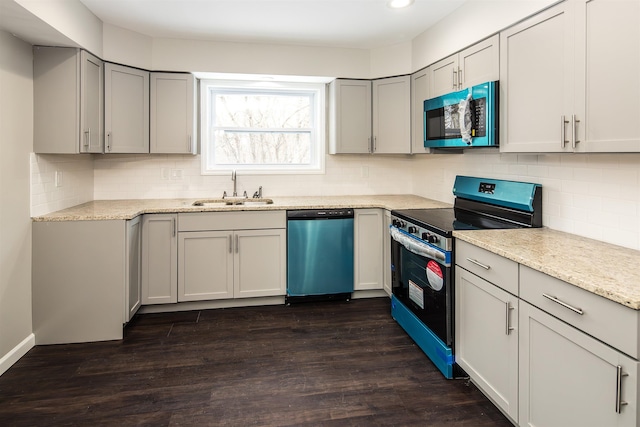 kitchen featuring light stone countertops, appliances with stainless steel finishes, dark hardwood / wood-style flooring, and sink