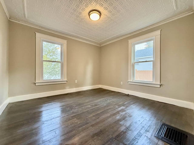 spare room with dark hardwood / wood-style floors, crown molding, and a wealth of natural light